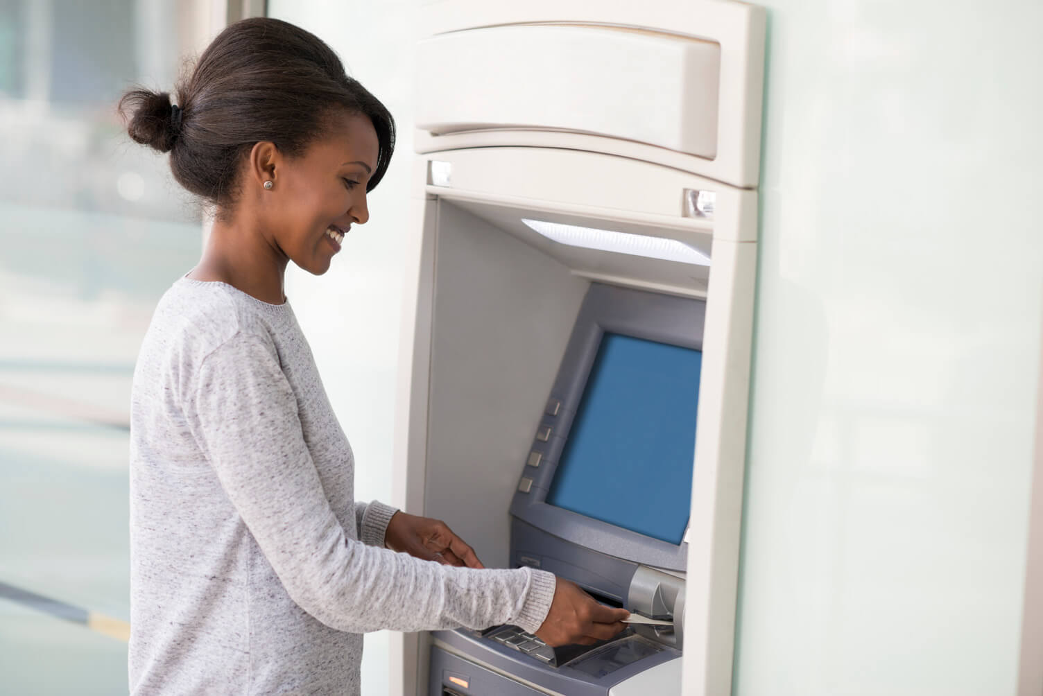 A woman withdrawing money from an ATM