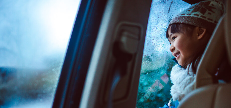 A young child in their parents’ car